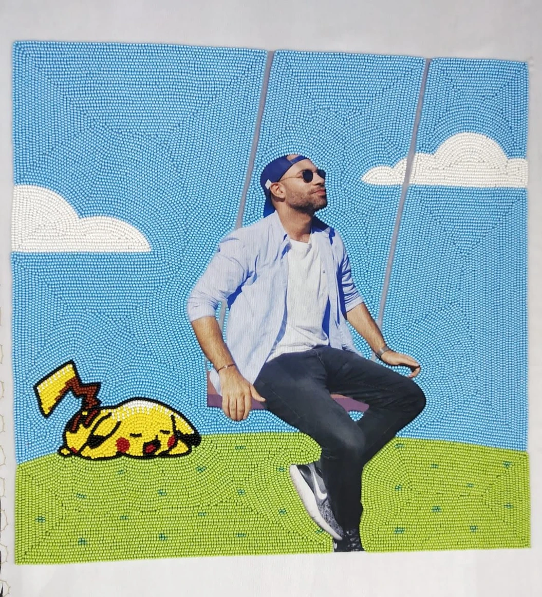 Portrait of a man on a swing surrounded by a blue beaded sky, white clouds and a sleeping Pikachu